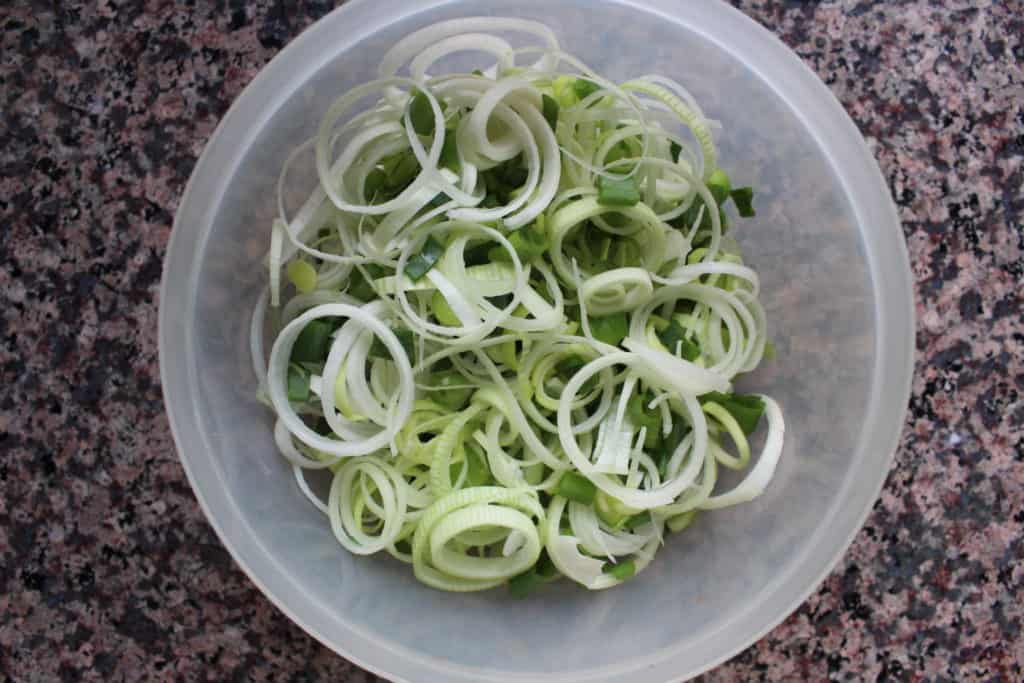 Clear bowl filled with chopped leeks 