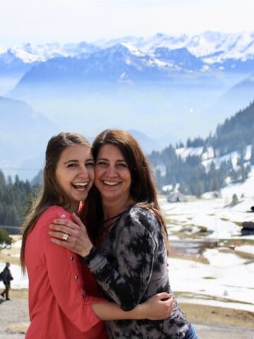 Alexandria and mom posing together in front of the Swiss Alps