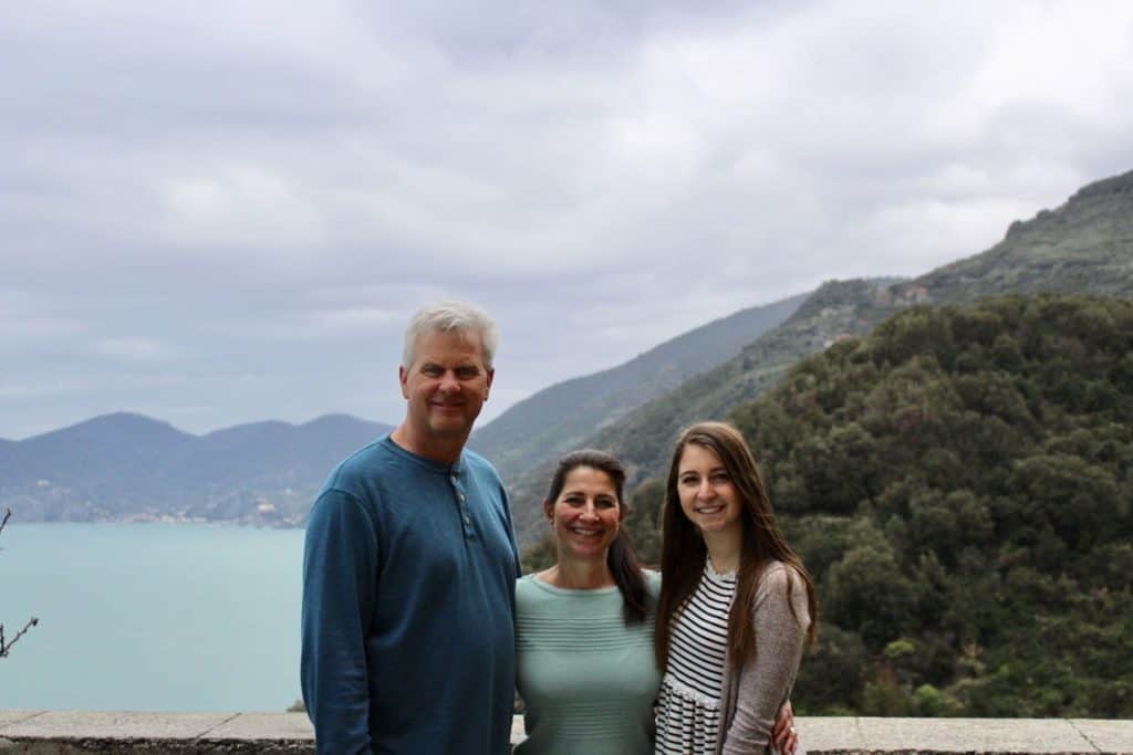 Alexandria with mom and dad in front of the cinque terre mountain