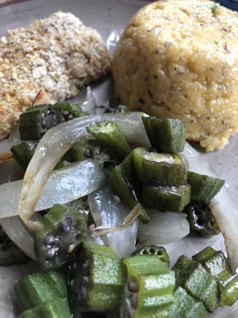 Close up of okra with Barbadian Cou Cou in the background