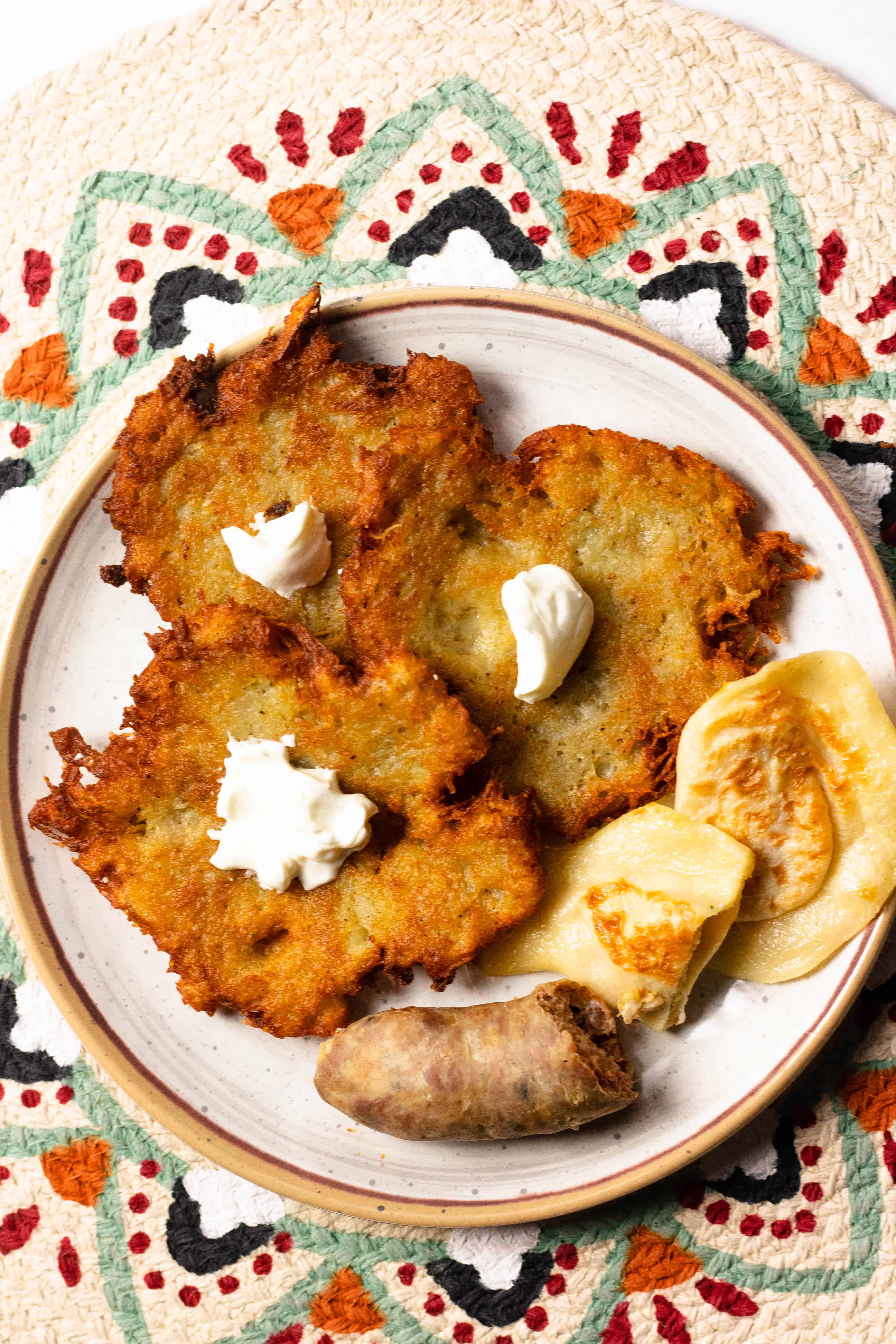 Plate of potato pancakes with a dollop of butter over each. 