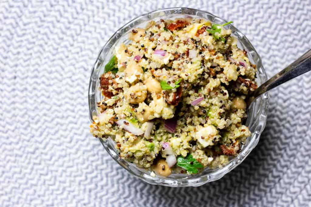 Overhead view of quinoa salad on blue and white place mat 