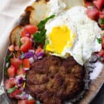 Bolivian Silpancho made with rice, a pan-fried burger, salsa, potatoes, and an egg