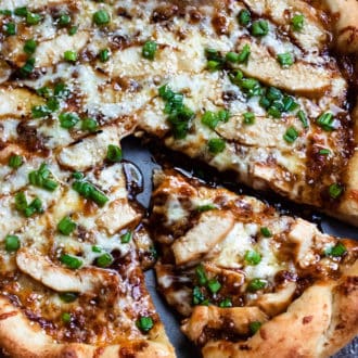 Honey Barbecue Chicken Pizza topped with barbecue sauce with a slice cut out.