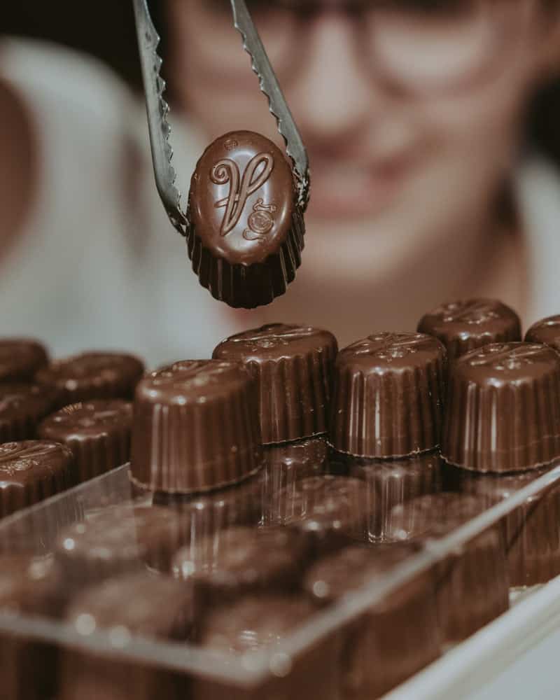 Tongs holding up Belgian chocolates.