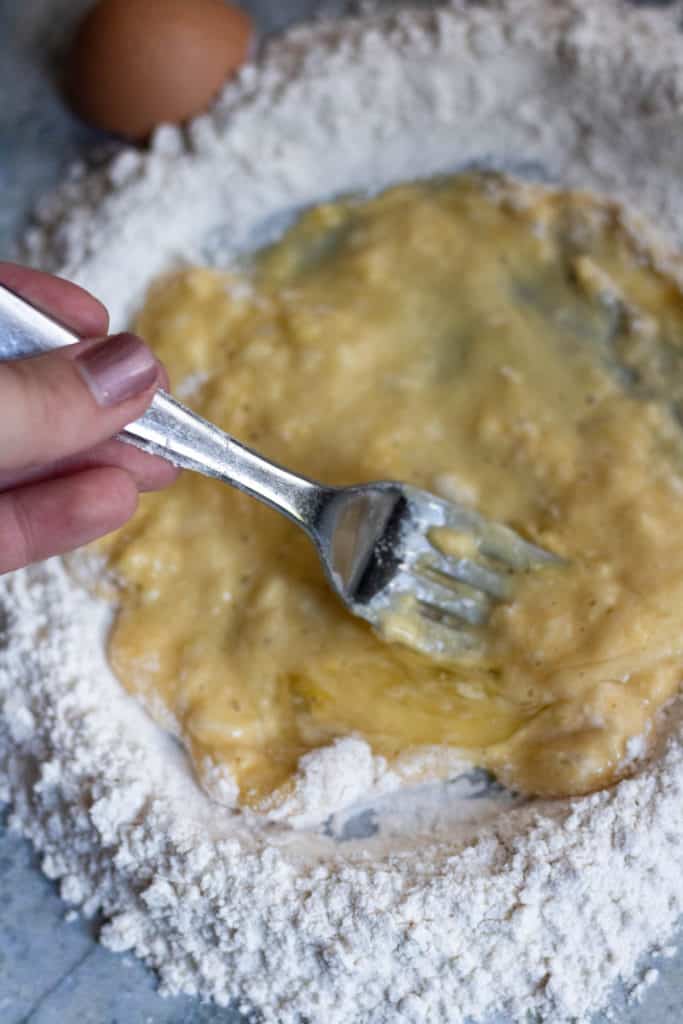 how to make  homemade pasta step 4: whisk in the flour