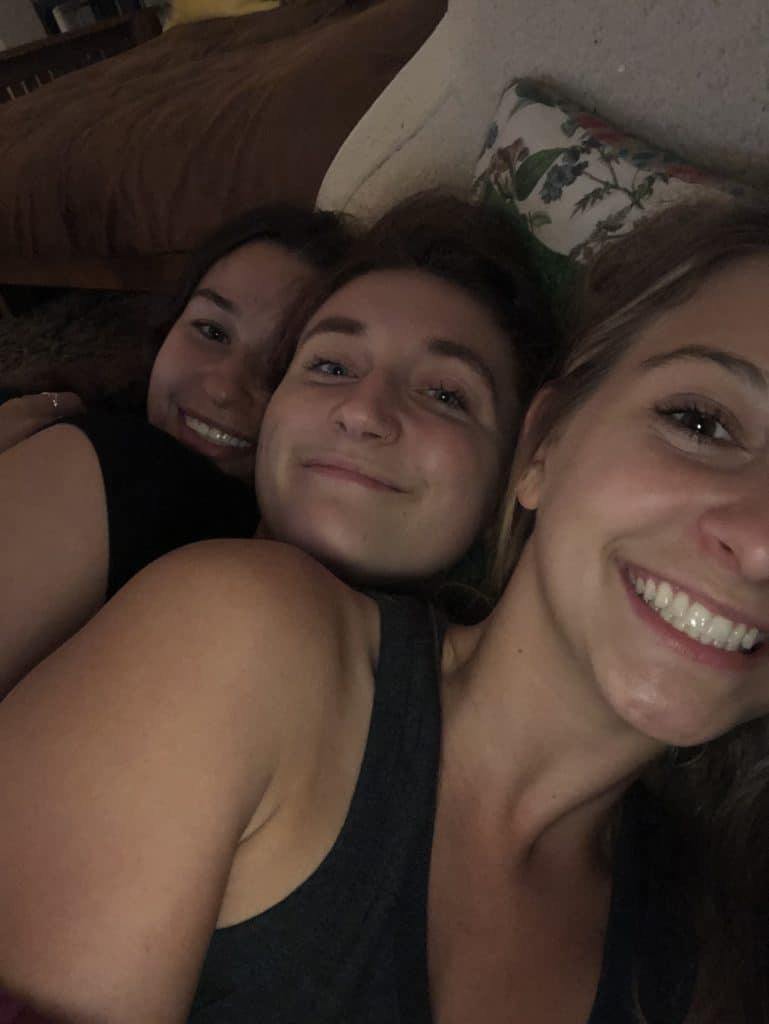 3 girls cuddling in bed. 