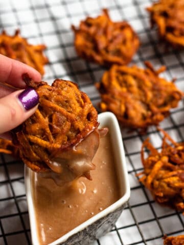 hand dipping sweet potato fritters