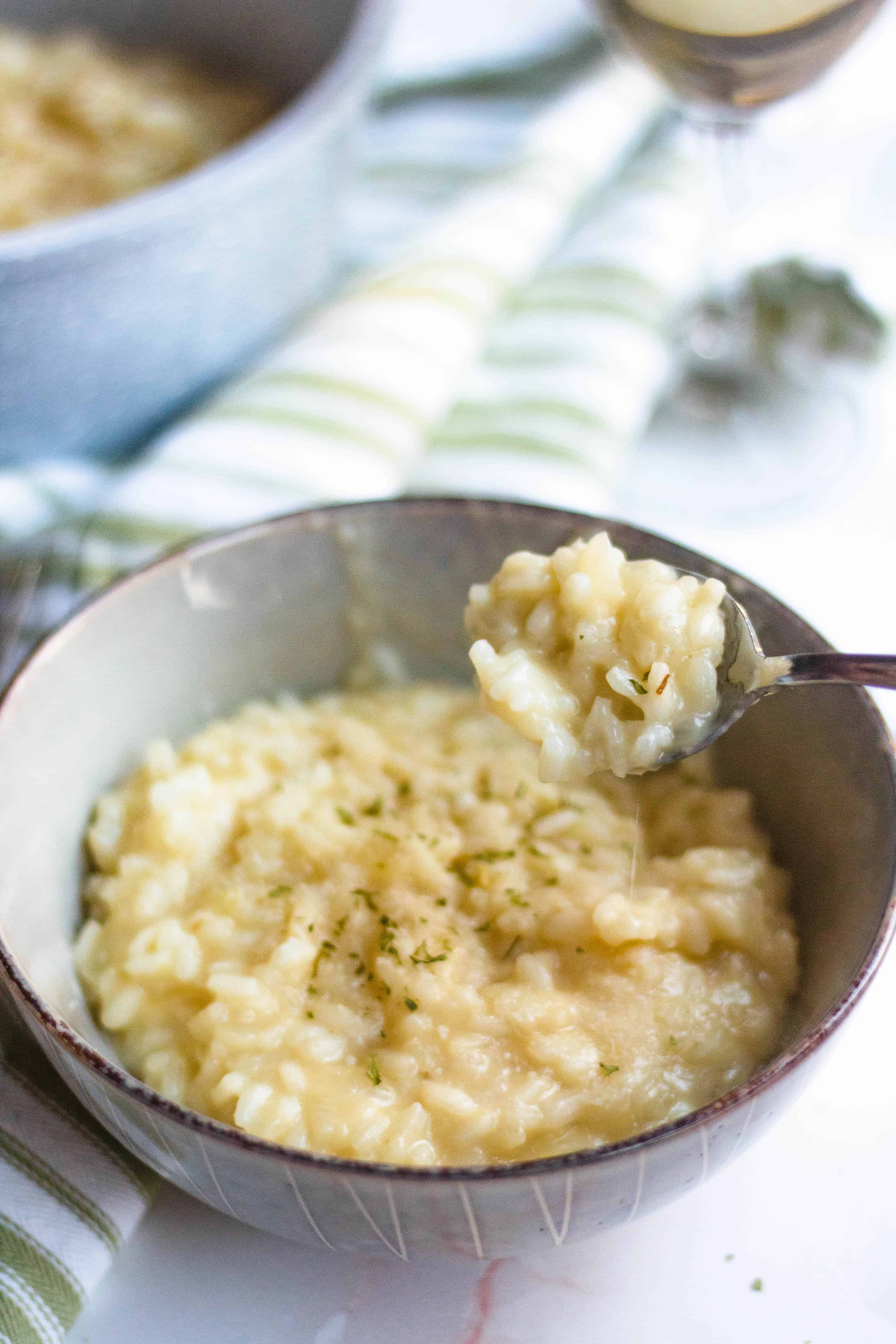 Spoonful of Parmesan risotto over a bowlful of the creamy risotto.