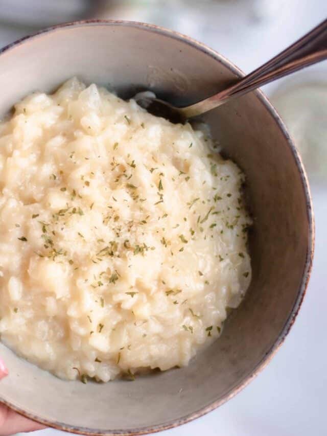 Spoonful of parmesan risotto laying in a bowl. 