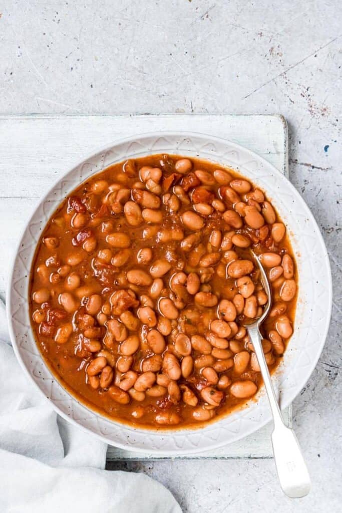 white bowl on white background filled with pinto beans