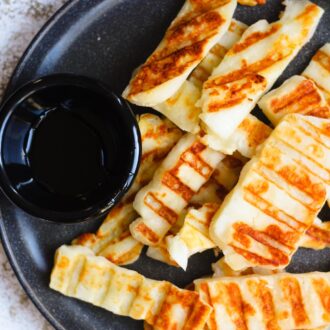 Grilled halloumi with bowl of honey