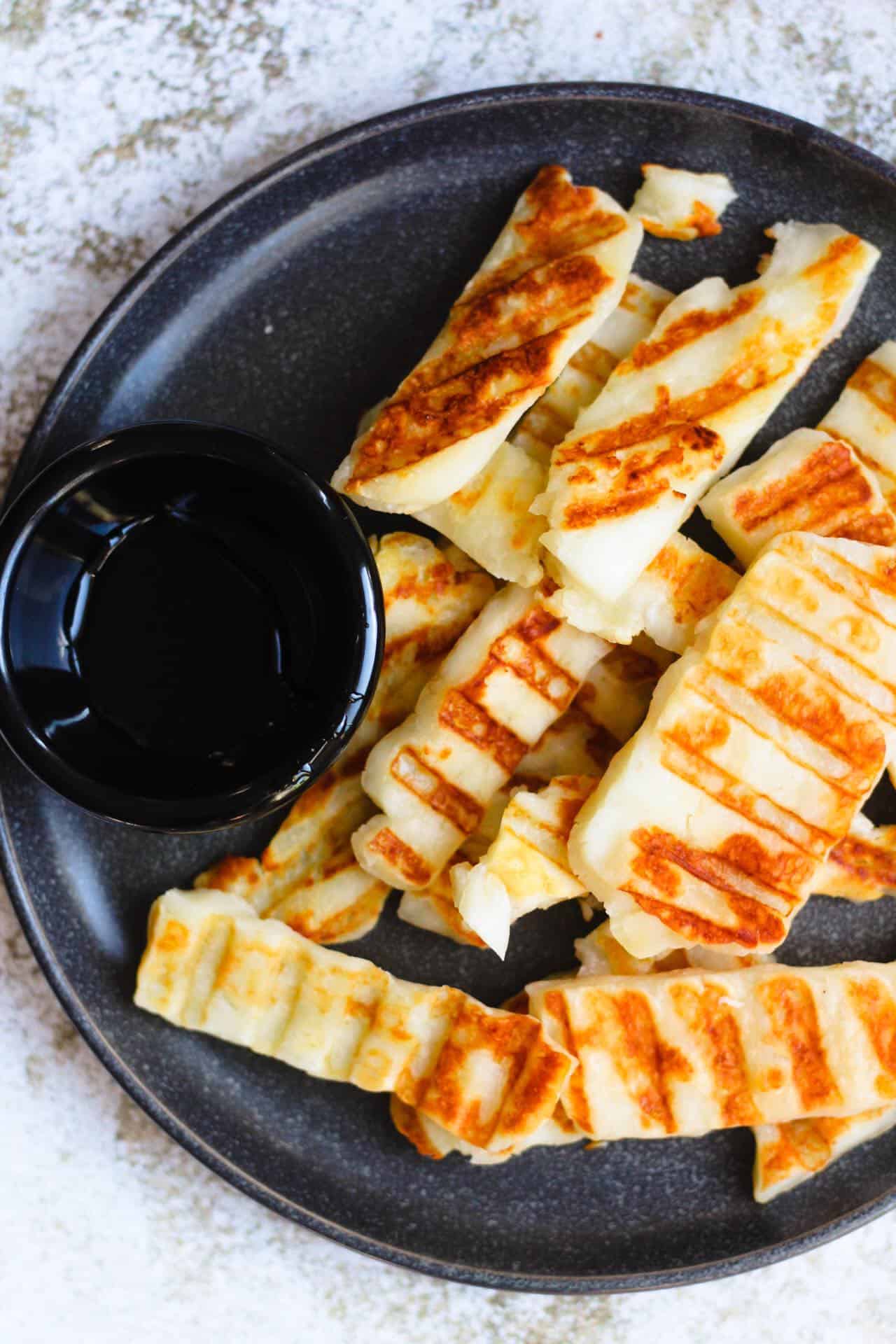 Grilled halloumi with bowl of honey
