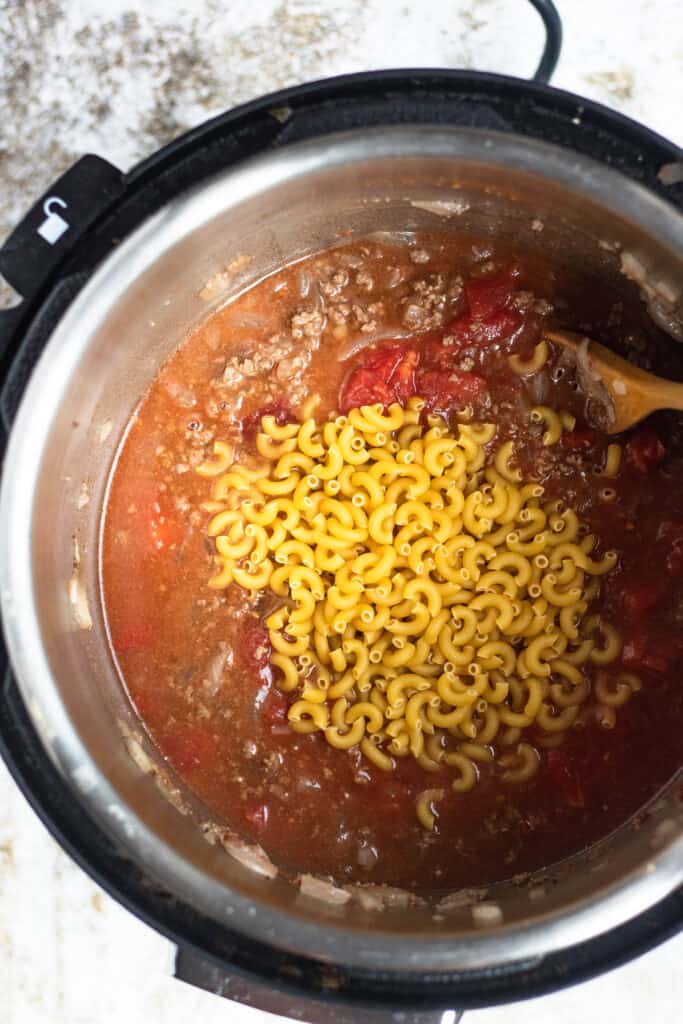 Instant Pot with goulash ingredients with elbow noodles 