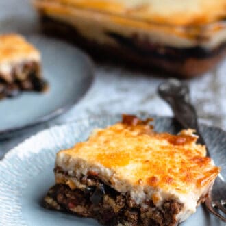 Moussaka recipe with a fork and a tray behind it