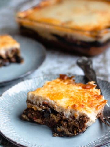 Moussaka recipe with a fork and a tray behind it