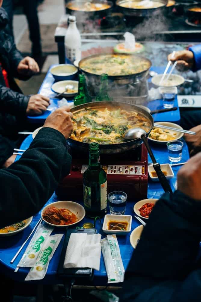 A restaurant table with communal serving dishes and individual bowls 