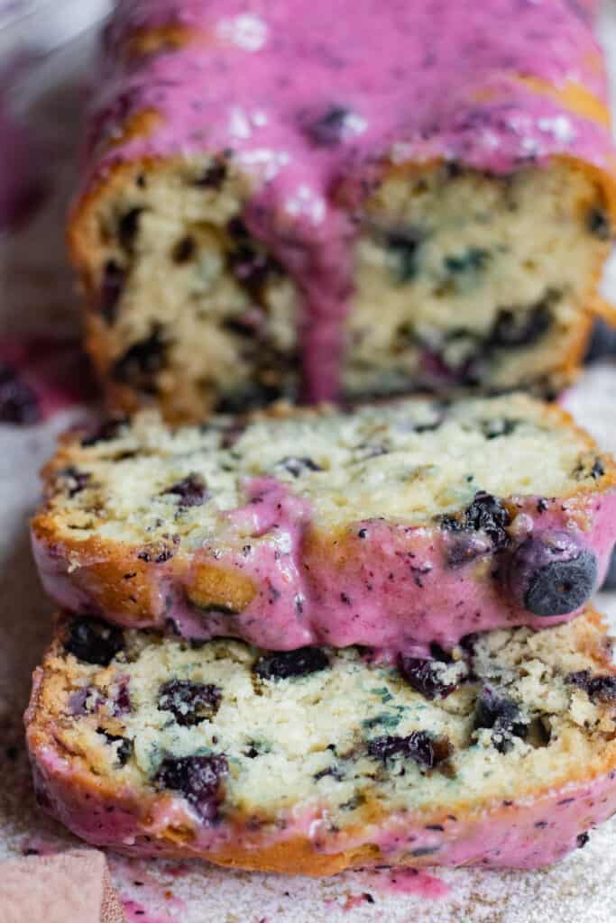 slices of blueberry bread from the front with glaze dripping down 