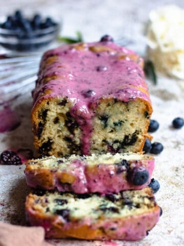 Blueberry bread loaf from the front with purple glaze