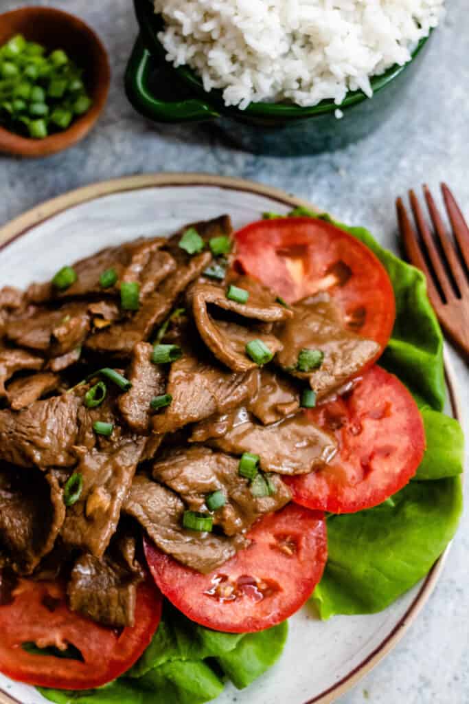 Overhead view of beef stir fry with tomatoes and lettuce