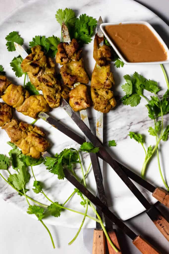 Full plate of Chicken Satay with Peanut sauce and cilantro 