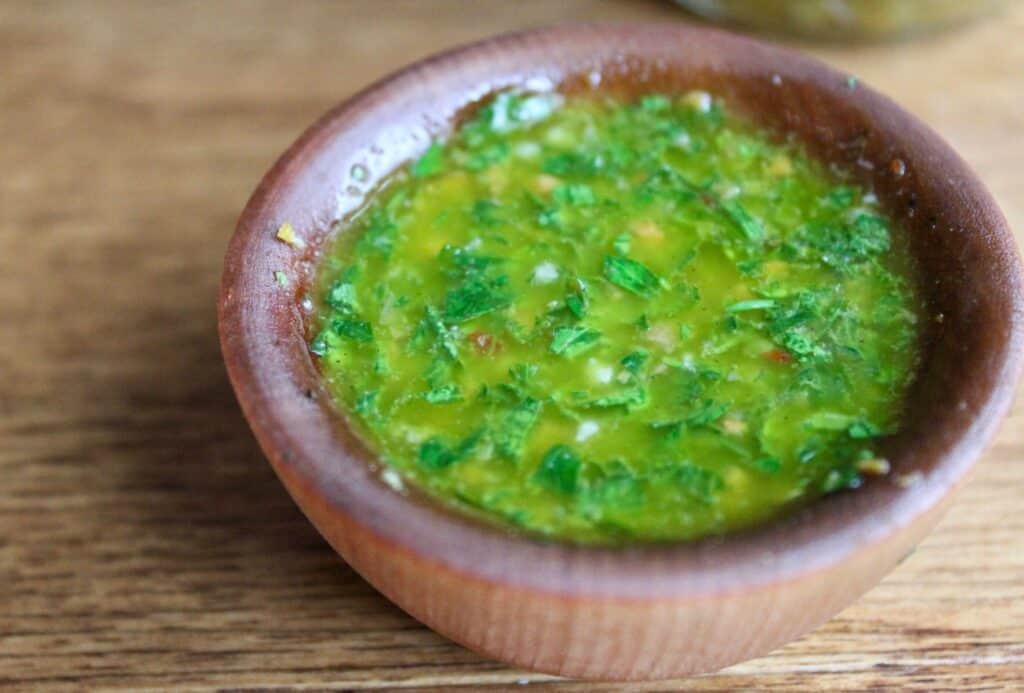 Brown bowl filled with chimichurri 