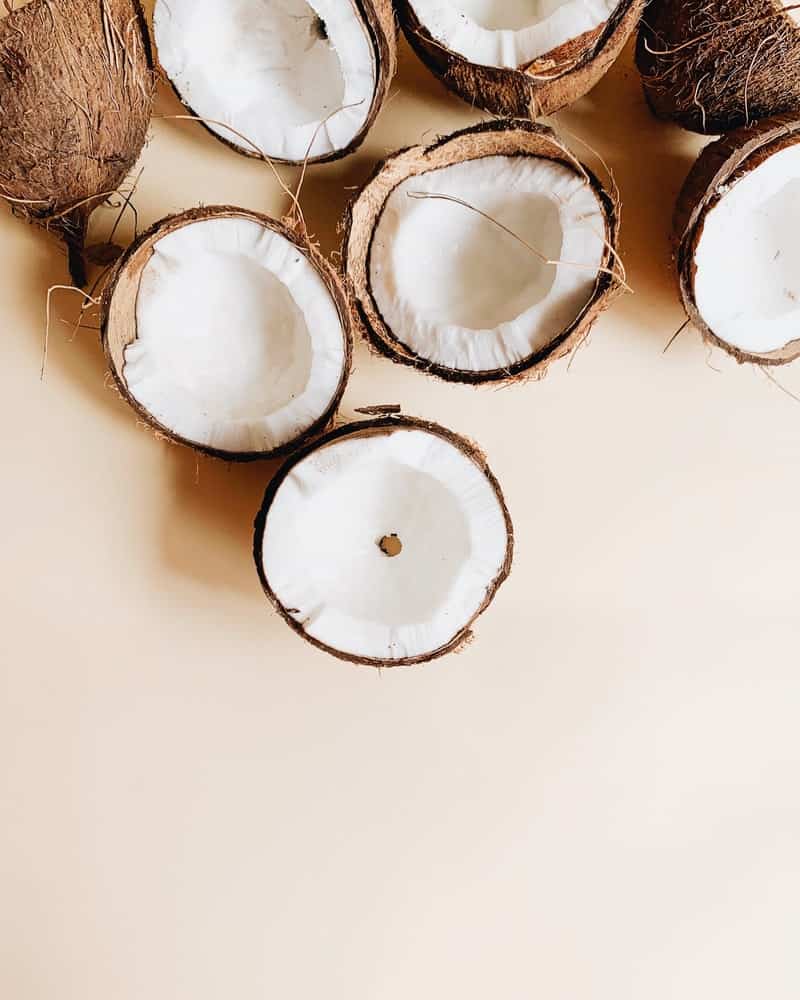 Coconut halves on a light pink background 