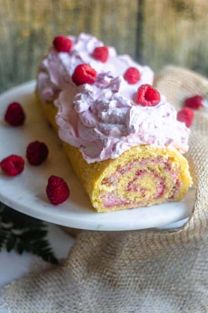 Swiss Roll on a cake plate with raspberries and burlap 