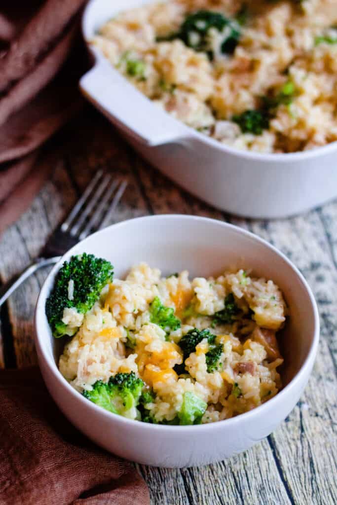 a small bowl of cheesy chicken and rice with broccoli 