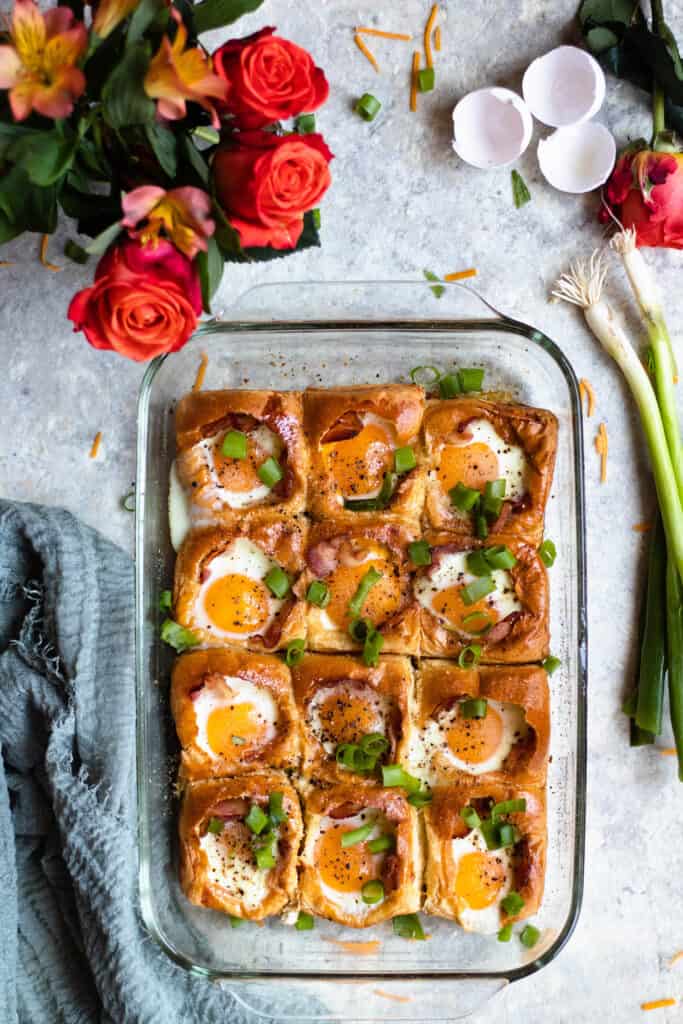 Overhead view of Egg in a Hole bake with roses and green onions