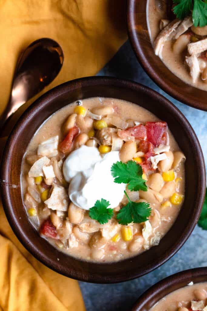 Close up of wooden bowl with white bean chicken chili 