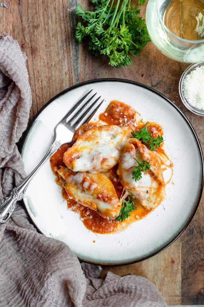 Stuffed shells with fork, parsley, and parmesan cheese