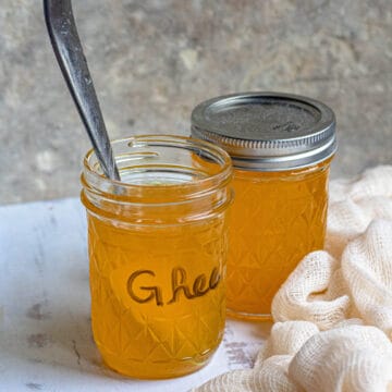 Jars of spiced ghee with cheesecloth next to the jars.