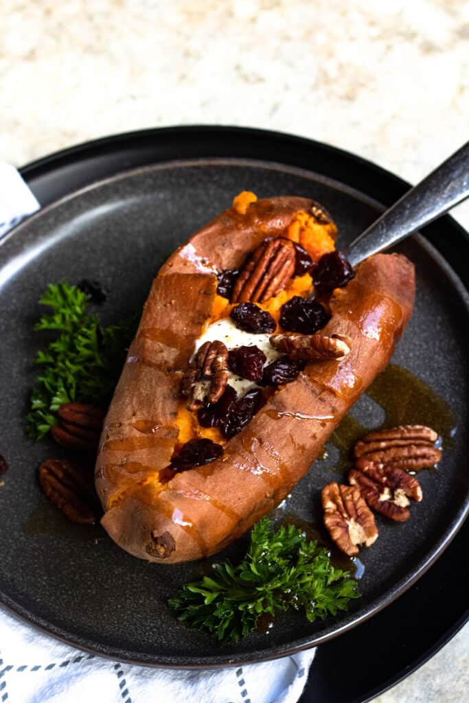 Fully dressed Sweet Potatoes with maple syrup, pecans, cranberries, and butter