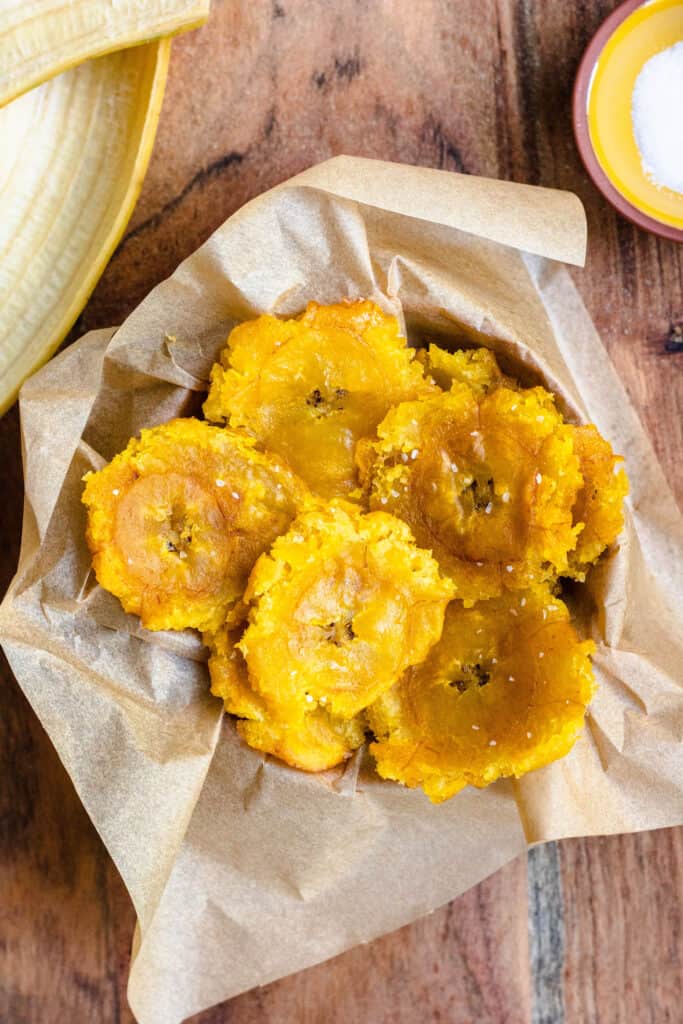 Bowl of tostones on brown parchment paper