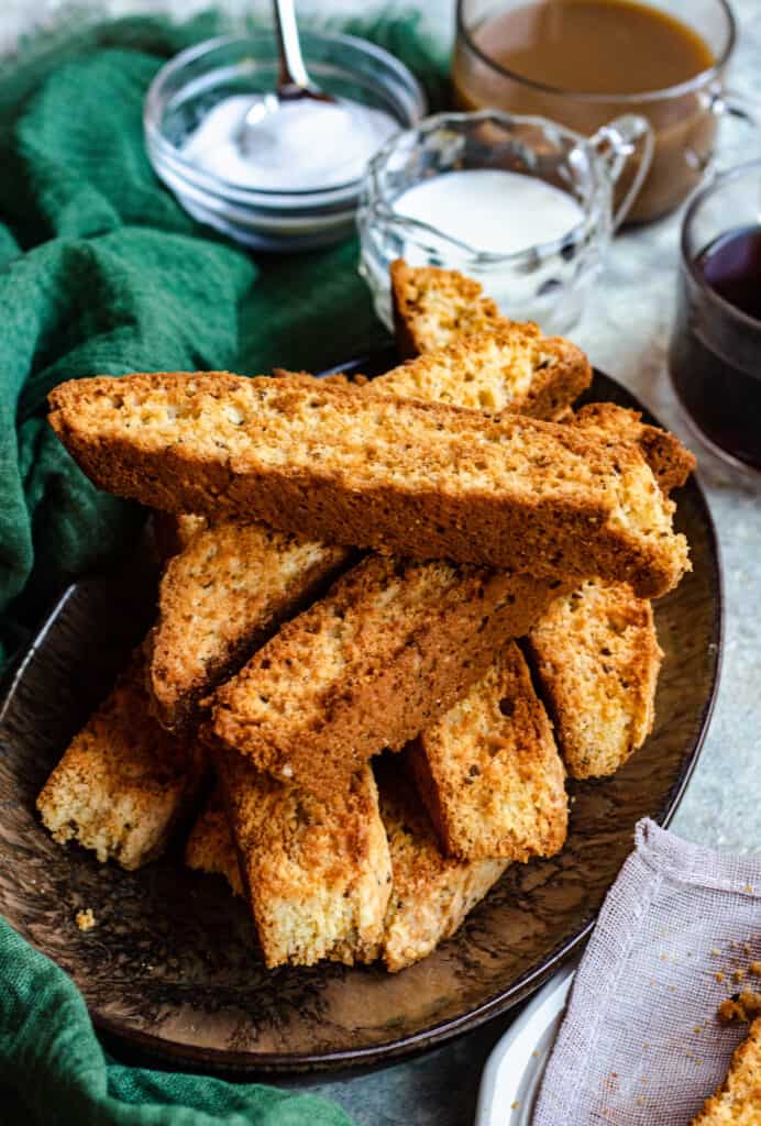 pile of biscotti with milk and coffee behind them