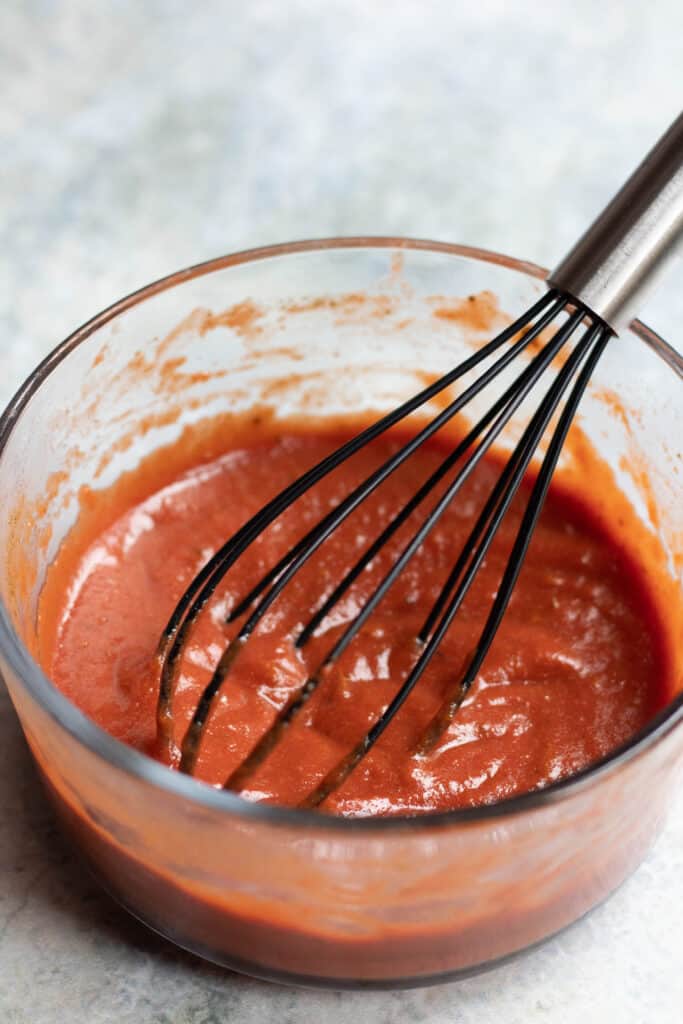 Pizza sauce with a whisk 