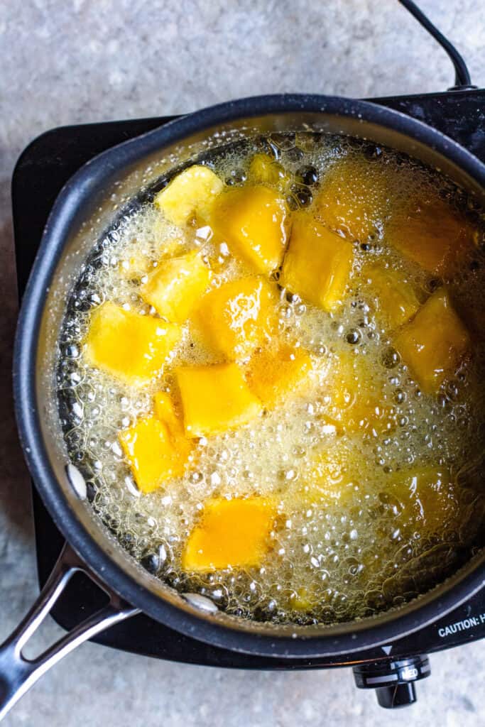 Mango and sugar boiling on the stove to make a syrup