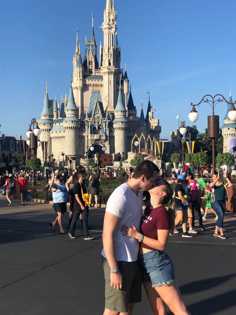 Alexandria and Matt kissing in front of the Magic Kingdom Castle.