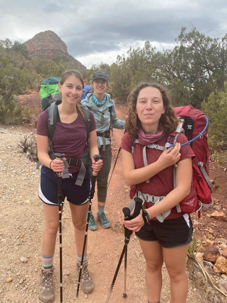 Alexandria and two girls posing with their hiking backpacks in the bottom of the grand canyon.