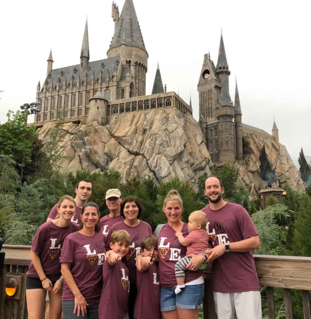 A group of people in front of the Harry Potter castle in Universal studios.