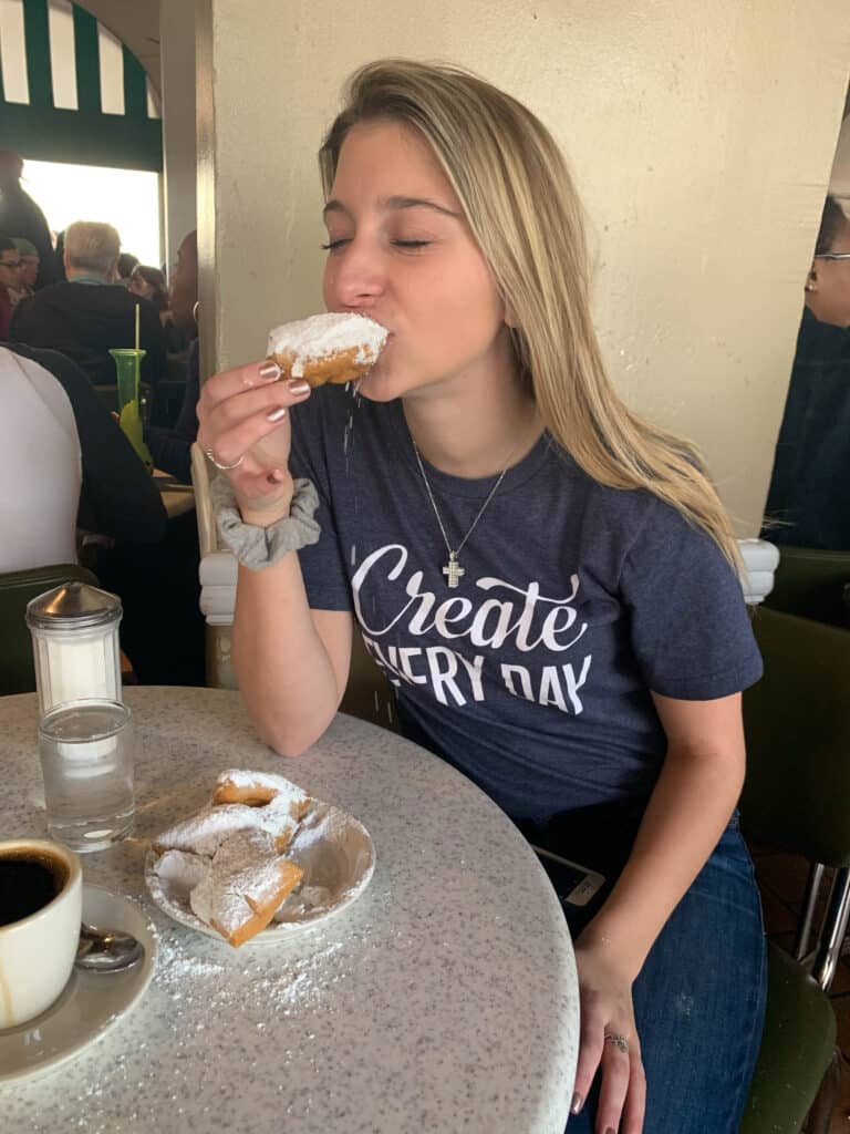 Alexandria taking a bite of a beignet in New Orleans.