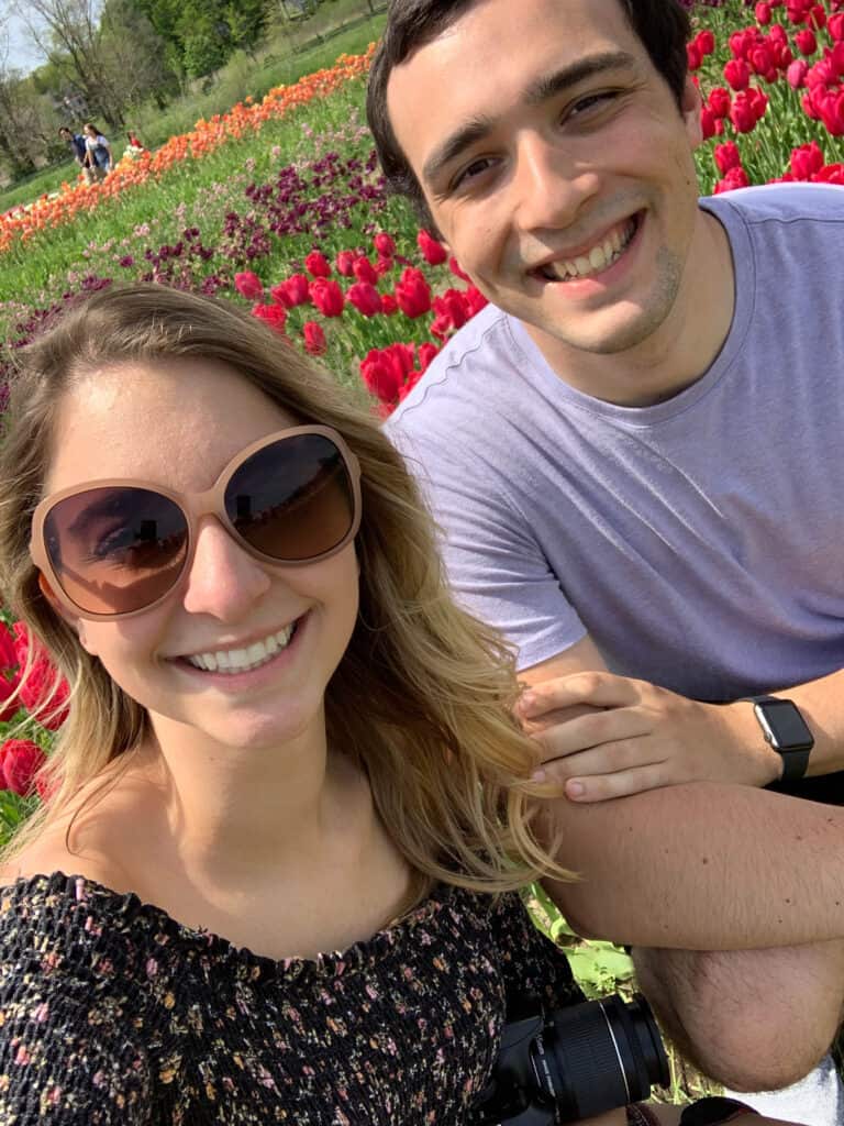 Alexandria and Matt taking a selfie in front of the tulips.
