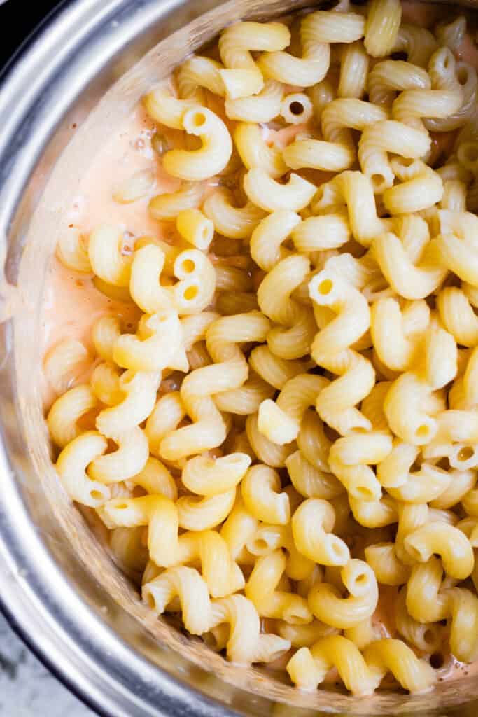 close up of macaroni in cheese sauce