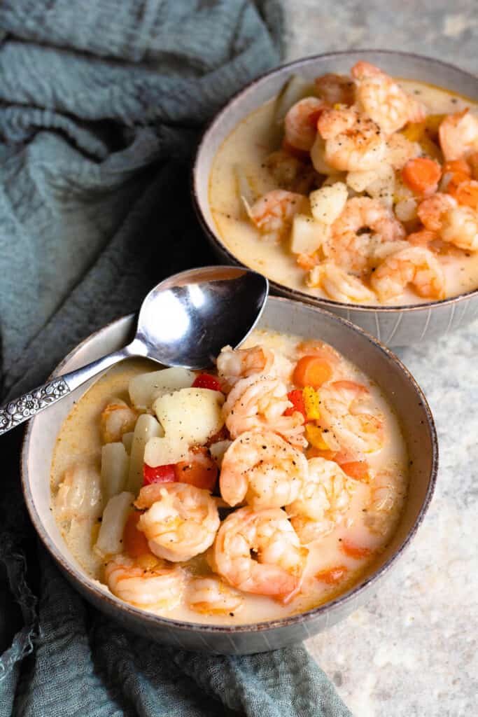 Two bowls of Shrimp Soup with a linen and a spoon 