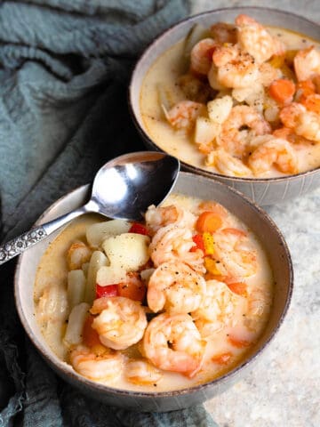 Shrimp soup in a bowl with a spoon next to the bowl.