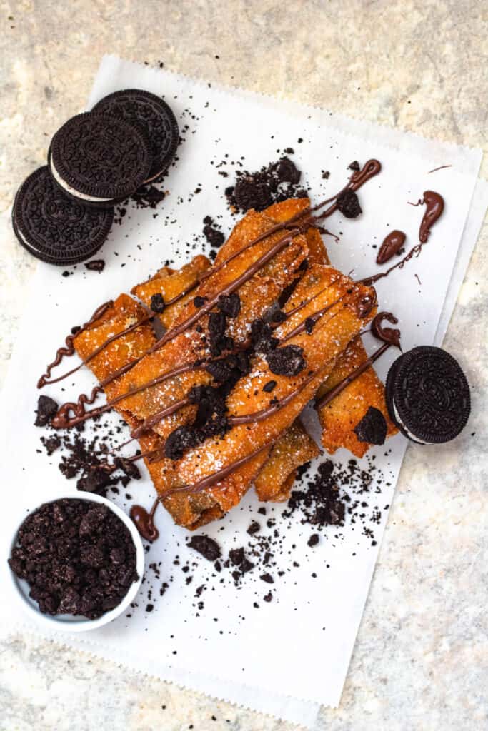 Overhead view of Oreo dessert egg rolls decorated with drizzled chocolate and Oreos 