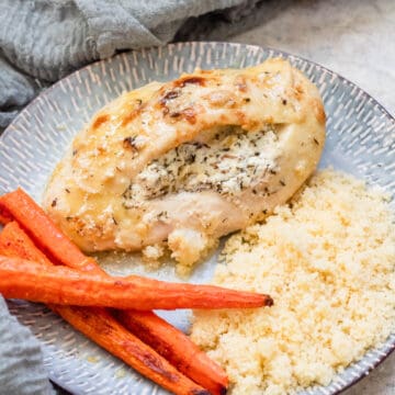 Stuffed chicken breast with couscous and roasted carrots on the side.