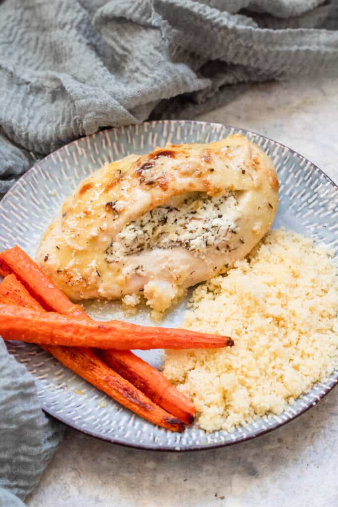 Plate of goat cheese stuffed chicken breast, couscous and carrots