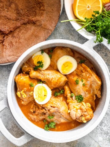 Doro wat in a small pot topped with hard boiled eggs and parsley.